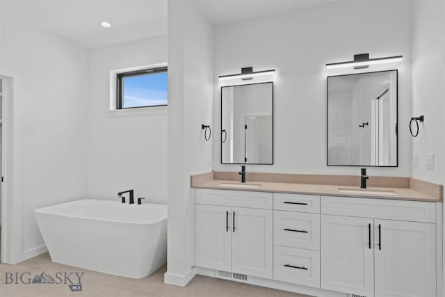 bathroom featuring a bathing tub, tile patterned flooring, and vanity