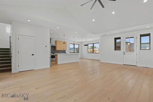 unfurnished living room with vaulted ceiling, light hardwood / wood-style flooring, and ceiling fan