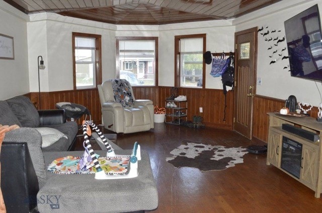 living room with hardwood / wood-style floors, lofted ceiling, wooden walls, and wooden ceiling