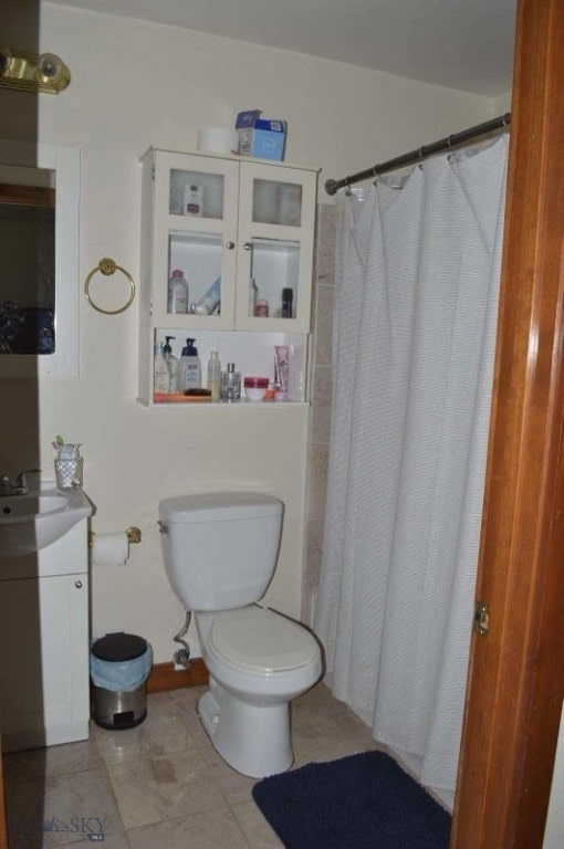 bathroom with curtained shower, tile patterned floors, vanity, and toilet