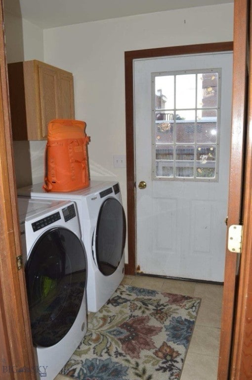 washroom with cabinets, light tile patterned floors, and washing machine and dryer