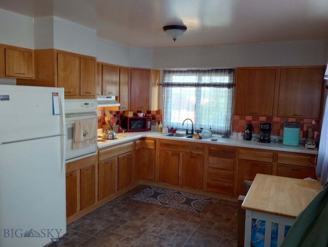 kitchen with sink, white appliances, and backsplash