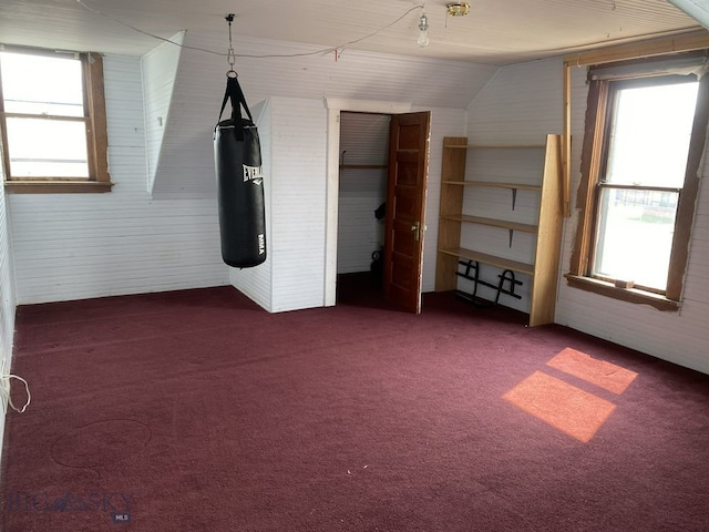 unfurnished bedroom with lofted ceiling and dark carpet