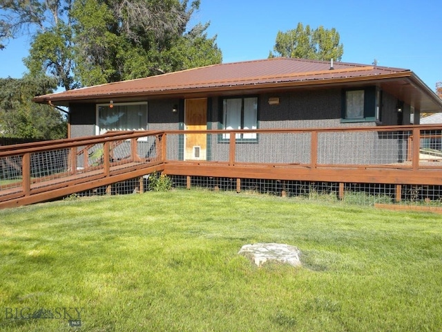 rear view of property with a lawn and a deck