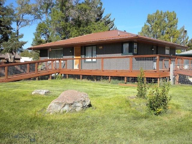 back of house with a deck and a yard