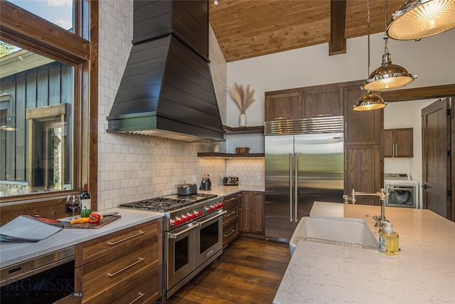 kitchen featuring custom range hood, washer / clothes dryer, wood ceiling, high quality appliances, and pendant lighting