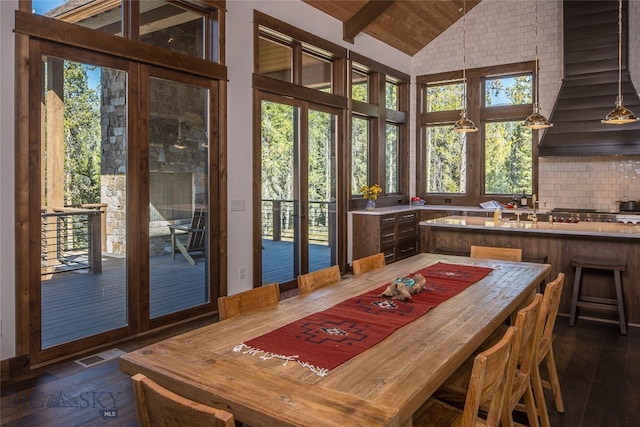 dining room featuring lofted ceiling with beams and dark hardwood / wood-style flooring