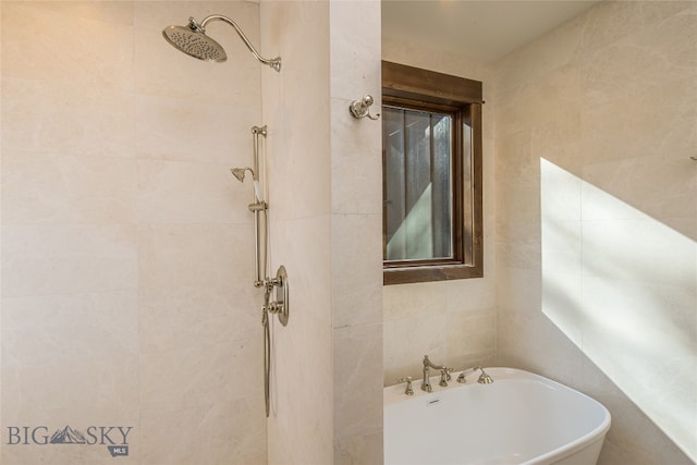 bathroom featuring tile walls and plus walk in shower