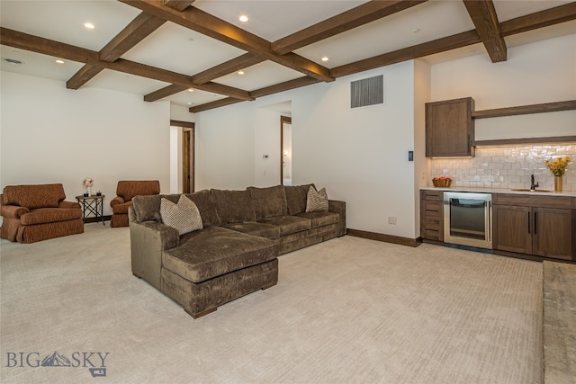 carpeted living room with beamed ceiling, wet bar, and coffered ceiling