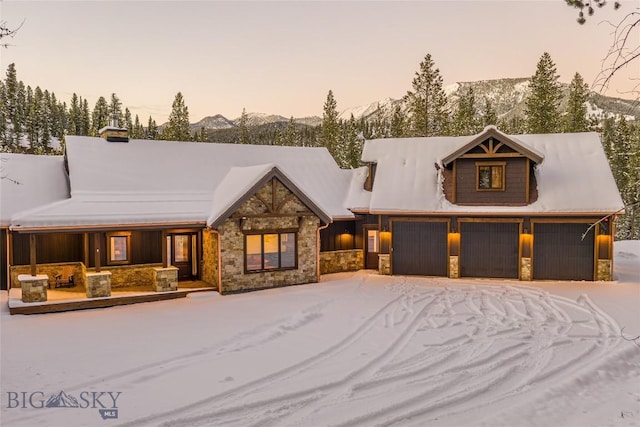 2250 Outlook Trl, Big Sky, MT 59716 - view of front facade with stone siding, an attached garage, and a mountain view