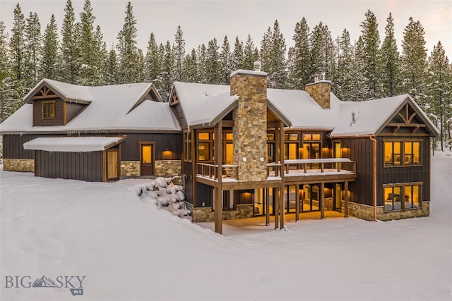 snow covered house featuring a deck