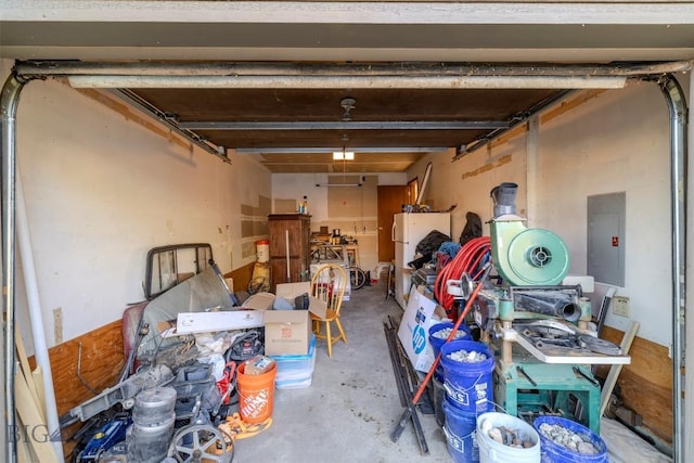 garage featuring electric panel and white refrigerator