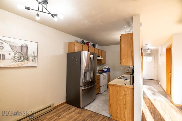 kitchen with sink, white electric range oven, baseboard heating, stainless steel refrigerator with ice dispenser, and light wood-type flooring