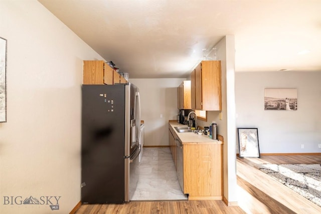 kitchen featuring light wood-type flooring, sink, and appliances with stainless steel finishes