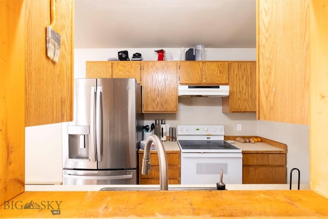 kitchen featuring electric range and stainless steel refrigerator with ice dispenser