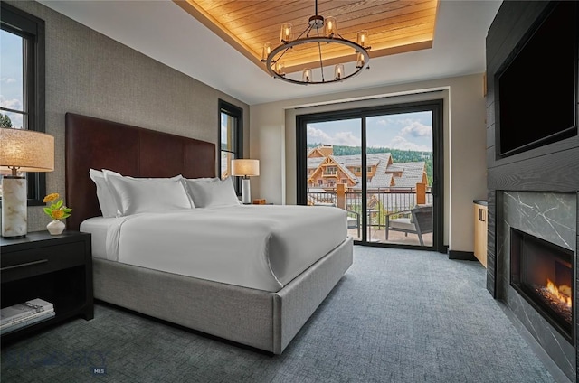 bedroom featuring a notable chandelier, a fireplace, wood ceiling, access to exterior, and a raised ceiling