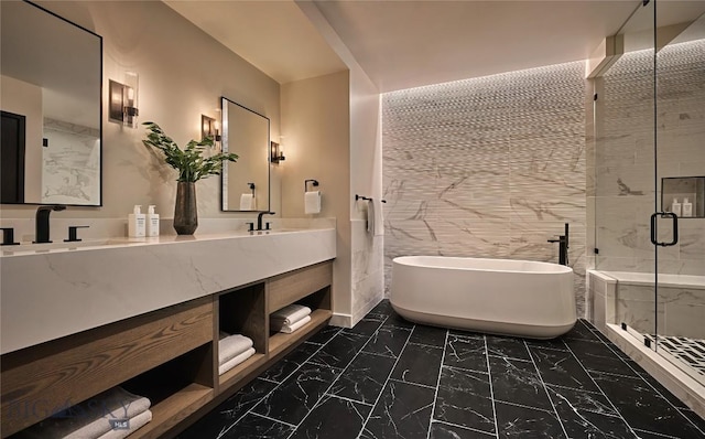 full bathroom featuring marble finish floor, double vanity, a freestanding bath, a sink, and a shower stall