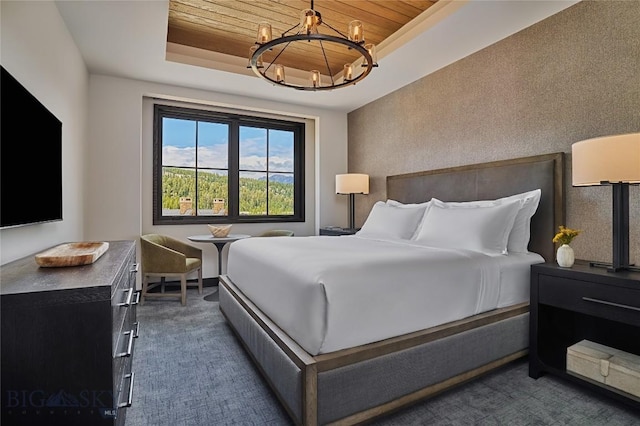 bedroom featuring a chandelier, a tray ceiling, wooden ceiling, and dark colored carpet