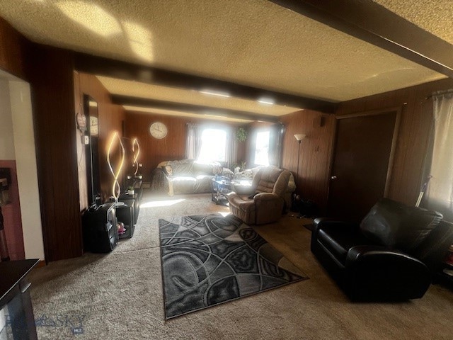 interior space with carpet floors, a textured ceiling, and beam ceiling