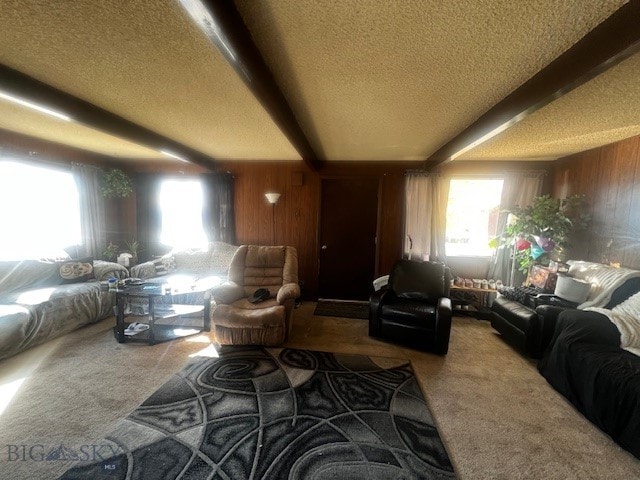 carpeted living room with a textured ceiling, wood walls, and beam ceiling