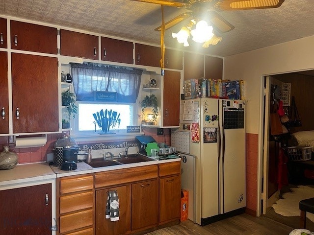 kitchen with hardwood / wood-style floors, ceiling fan, white refrigerator, and sink