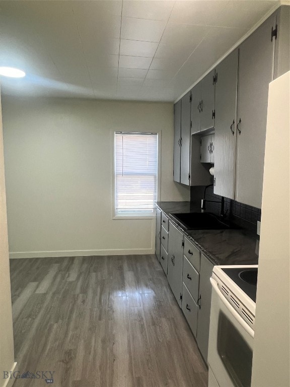 kitchen featuring white electric range oven, sink, light hardwood / wood-style floors, and gray cabinetry