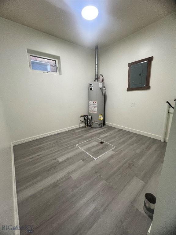 interior space with electric panel, hardwood / wood-style floors, and water heater