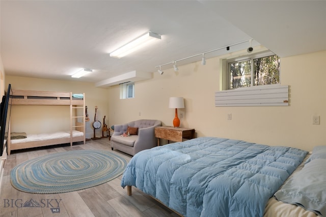 bedroom with hardwood / wood-style floors and rail lighting