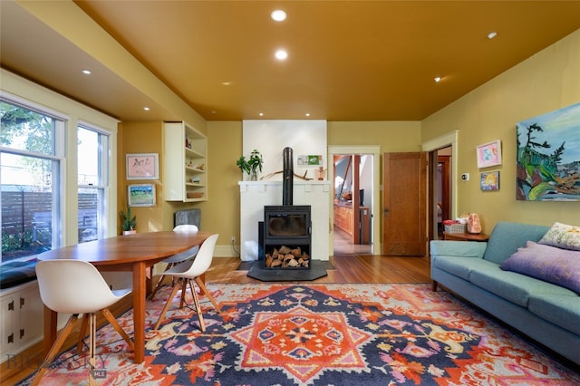 living room with a wood stove and wood-type flooring