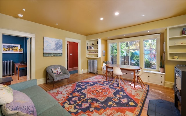 interior space featuring radiator heating unit and light hardwood / wood-style flooring