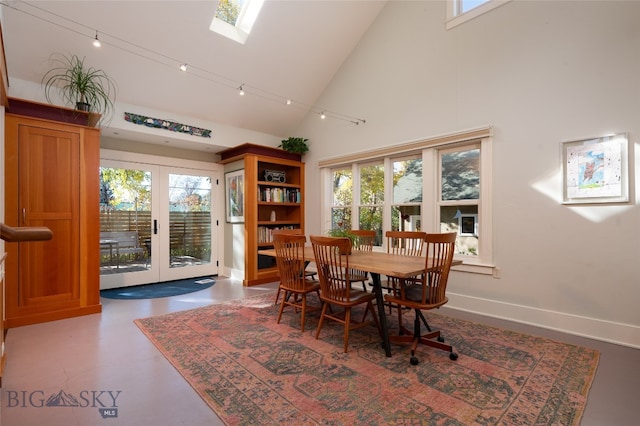 dining space featuring french doors, plenty of natural light, concrete flooring, and high vaulted ceiling