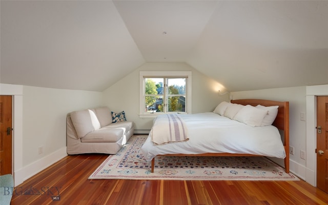 bedroom with lofted ceiling, dark hardwood / wood-style floors, and baseboard heating