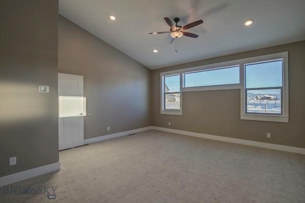 carpeted spare room featuring ceiling fan and high vaulted ceiling