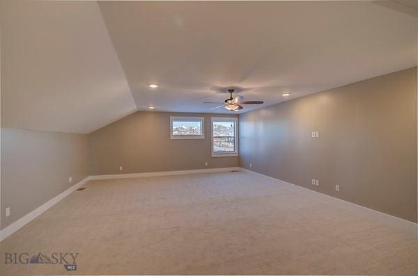 additional living space featuring ceiling fan, light colored carpet, and vaulted ceiling