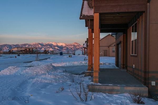 yard covered in snow featuring a mountain view