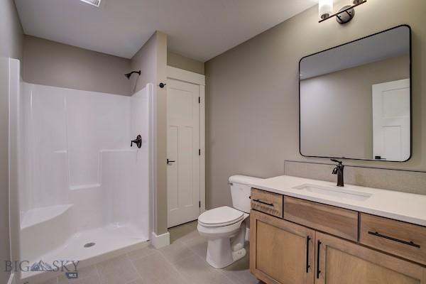 bathroom with vanity, tile patterned floors, toilet, and walk in shower