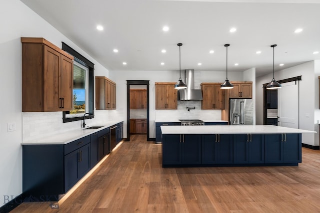 kitchen featuring wall chimney exhaust hood, dark hardwood / wood-style floors, stainless steel appliances, and a spacious island