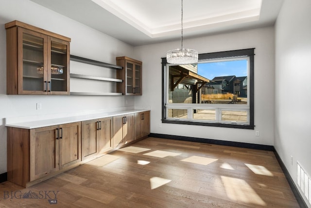 119 Clancy Way, Bozeman, MT 59718 - unfurnished dining area featuring dark wood-style flooring, a raised ceiling, a chandelier, and baseboards