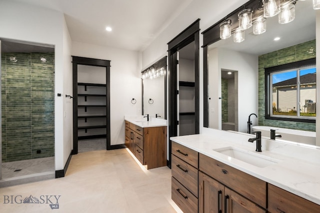 bathroom with tile patterned flooring, a shower with door, and vanity