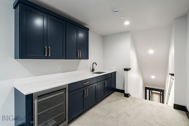 bar featuring beverage cooler, blue cabinets, sink, and light carpet