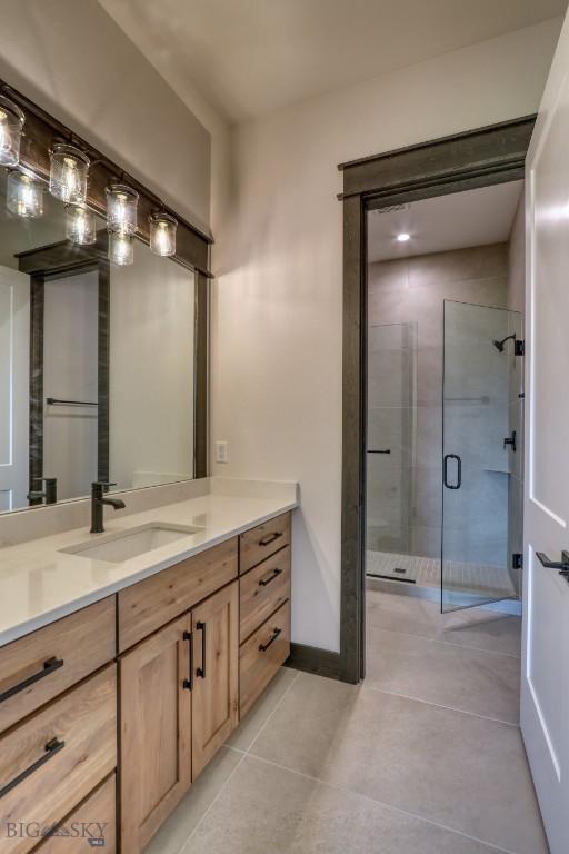 119 Clancy Way, Bozeman, MT 59718 - full bathroom featuring a shower stall, vanity, tile patterned floors, and baseboards