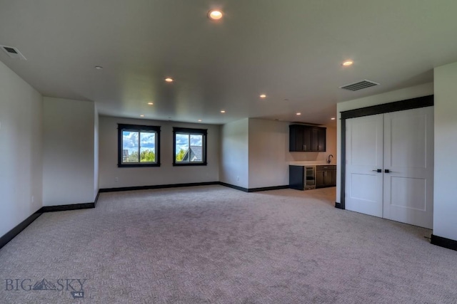 119 Clancy Way, Bozeman, MT 59718 - unfurnished living room with light colored carpet, recessed lighting, baseboards, and a sink