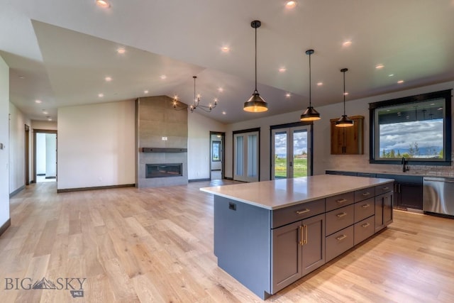 119 Clancy Way, Bozeman, MT 59718 - kitchen featuring stainless steel dishwasher, a sink, light countertops, a kitchen island, and light wood-style flooring