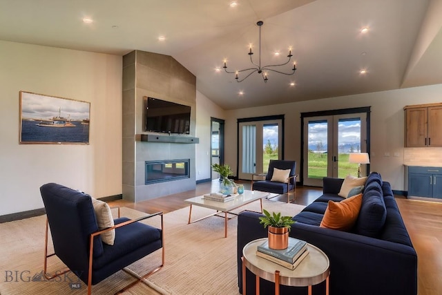 119 Clancy Way, Bozeman, MT 59718 - living room with lofted ceiling, a chandelier, a tiled fireplace, light wood-type flooring, and baseboards