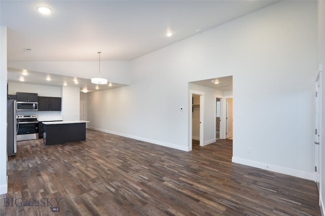 kitchen with stainless steel appliances, dark hardwood / wood-style floors, high vaulted ceiling, and a kitchen island