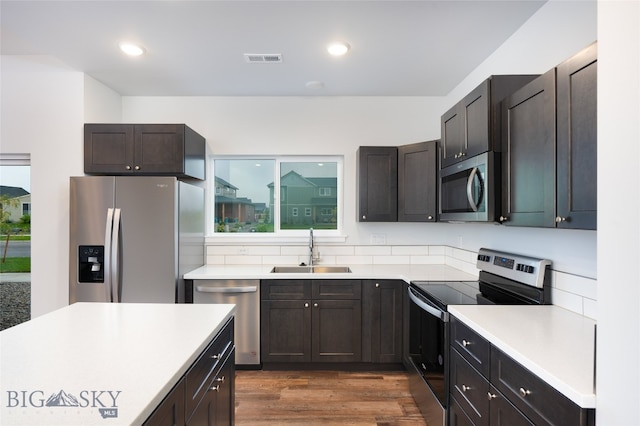 kitchen featuring stainless steel appliances, sink, and dark hardwood / wood-style flooring