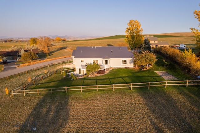 back of property with a yard and a rural view