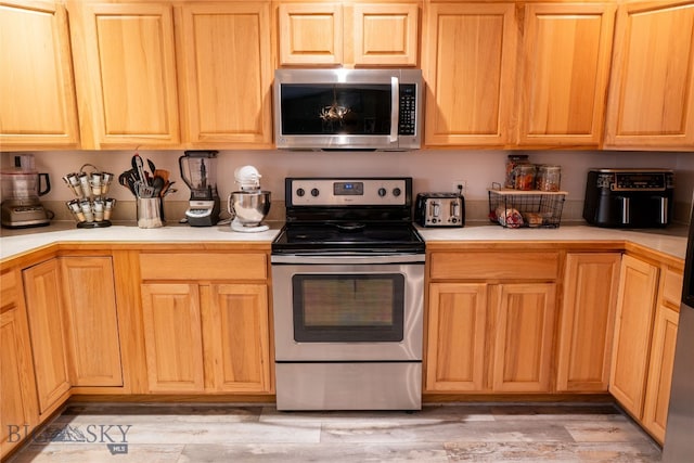 kitchen featuring stainless steel appliances and light hardwood / wood-style floors