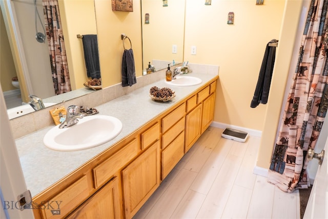 bathroom featuring vanity, toilet, wood-type flooring, and curtained shower