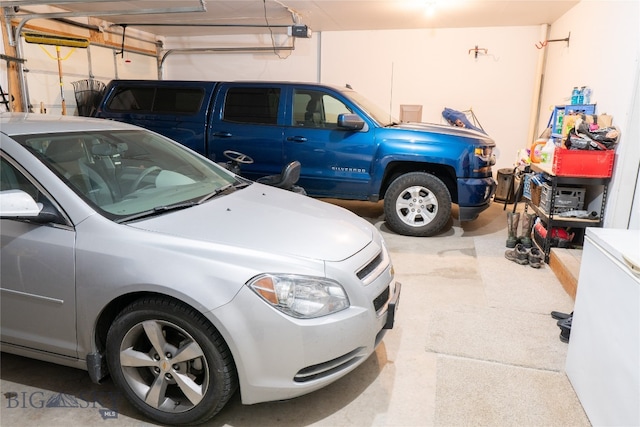 garage with a garage door opener and white refrigerator